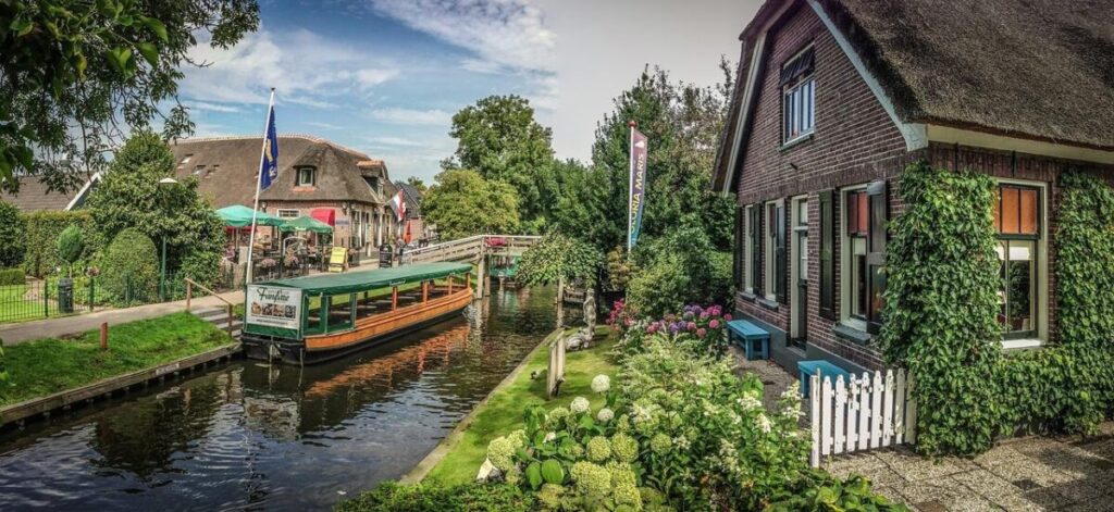 Elektrische punter voor varen in Giethoorn met bruggetjes en traditionele woningen langs het water