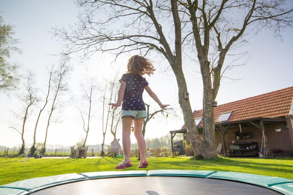 Ingegraven trampoline met gelijk springoppervlak in tuinbodem voor veilig en esthetisch spelen